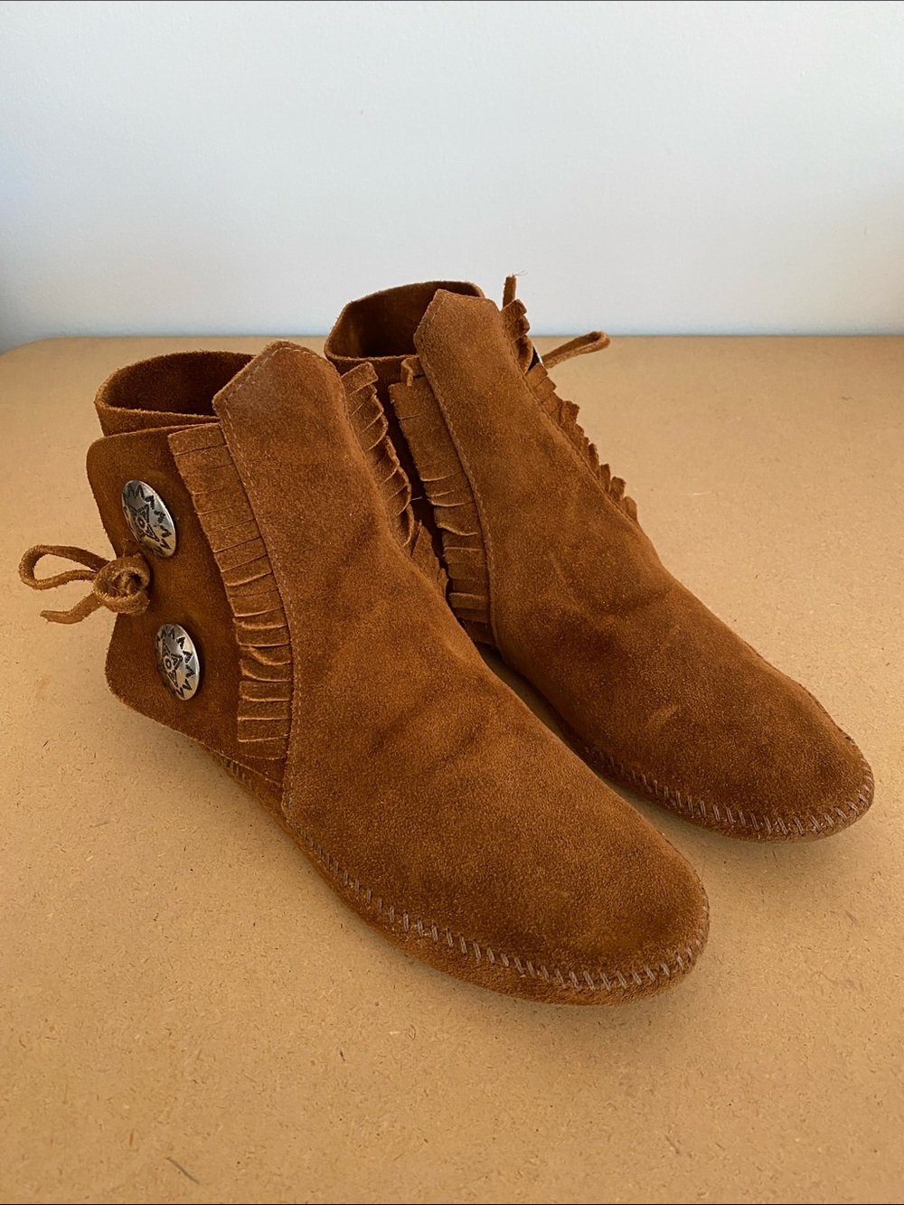 Minnetonka Moccasins. Brown Suede with silver tone accents.